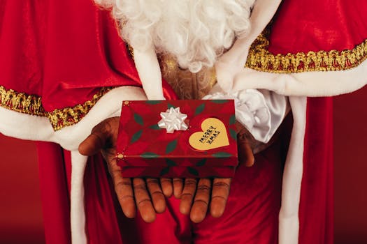 Close-up of a Santa Claus costume holding a festive Christmas gift box.
